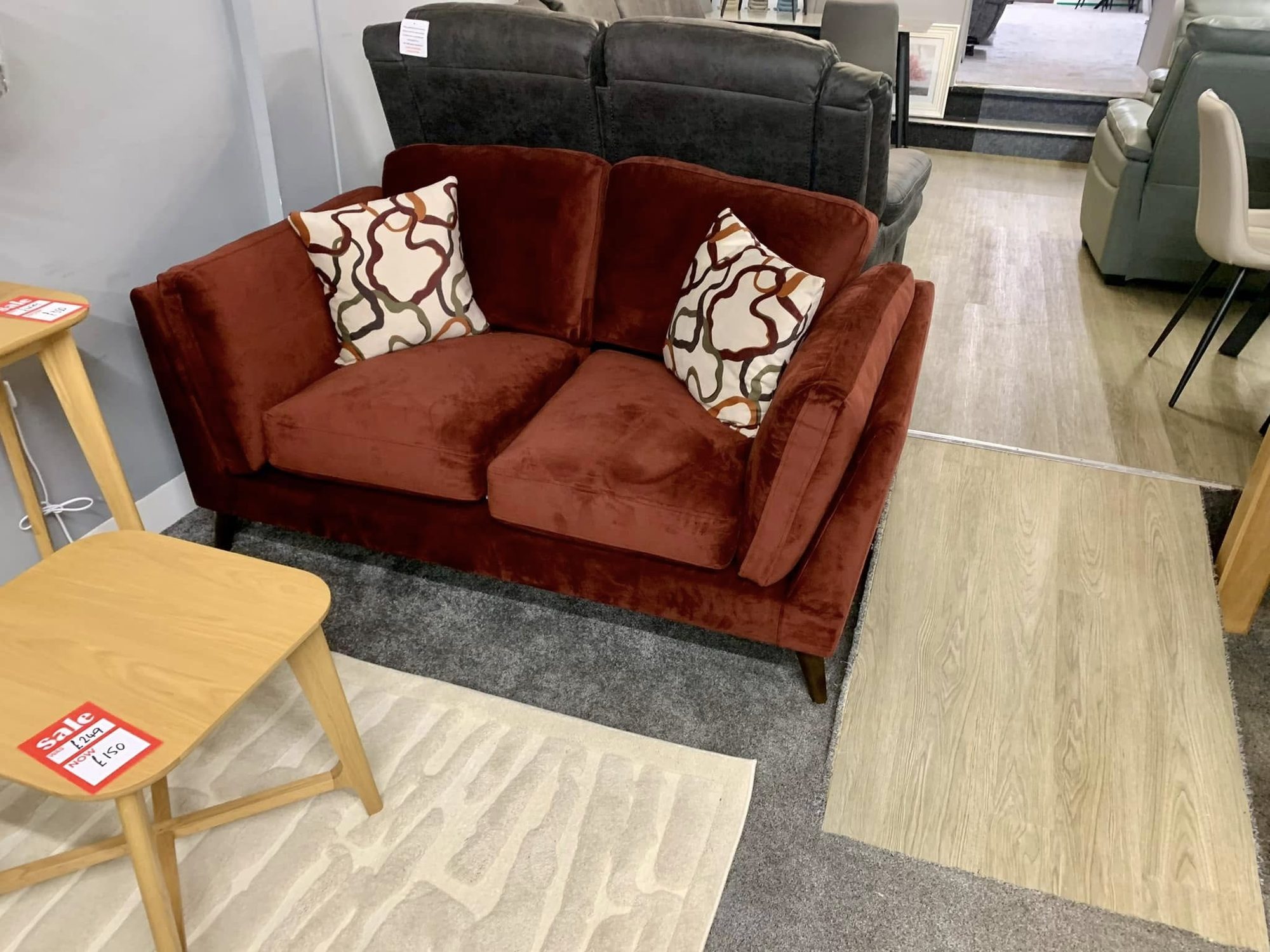 Rust velvet loveseat with patterned cushions