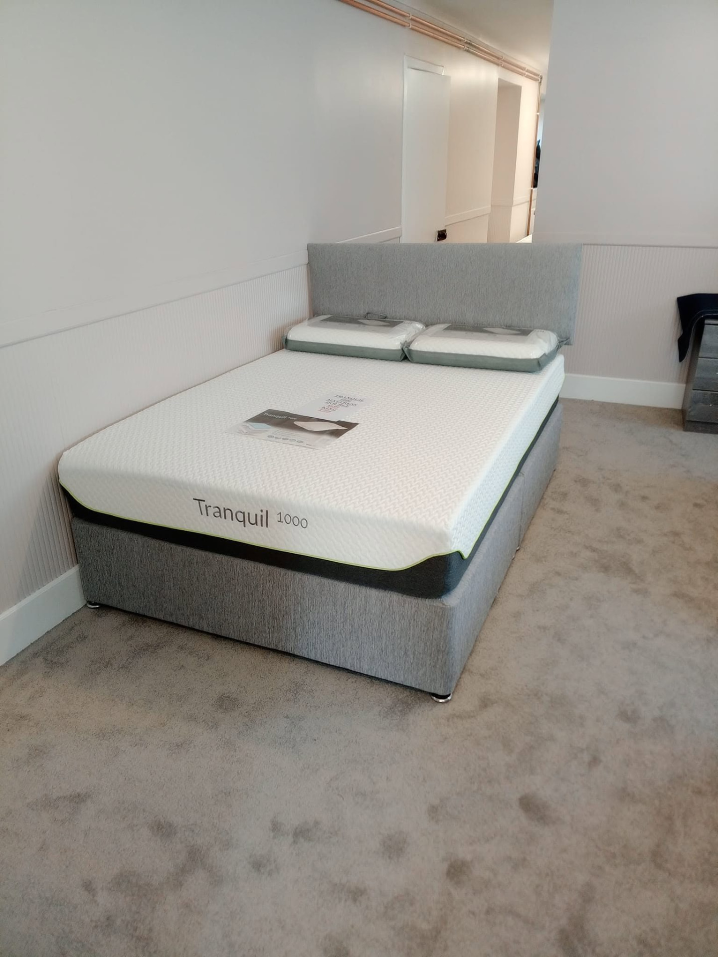 Tranquil 1000 pocket sprung mattress on a grey upholstered divan base in the Keith bed showroom