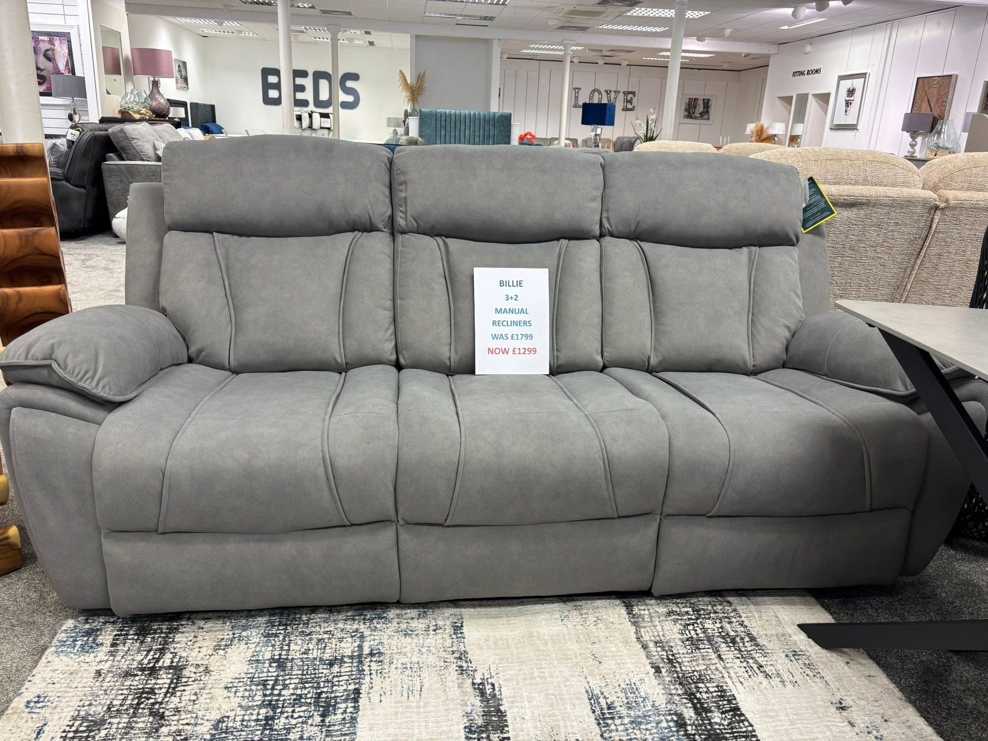 Billie grey fabric three-seater recliner sofa on display