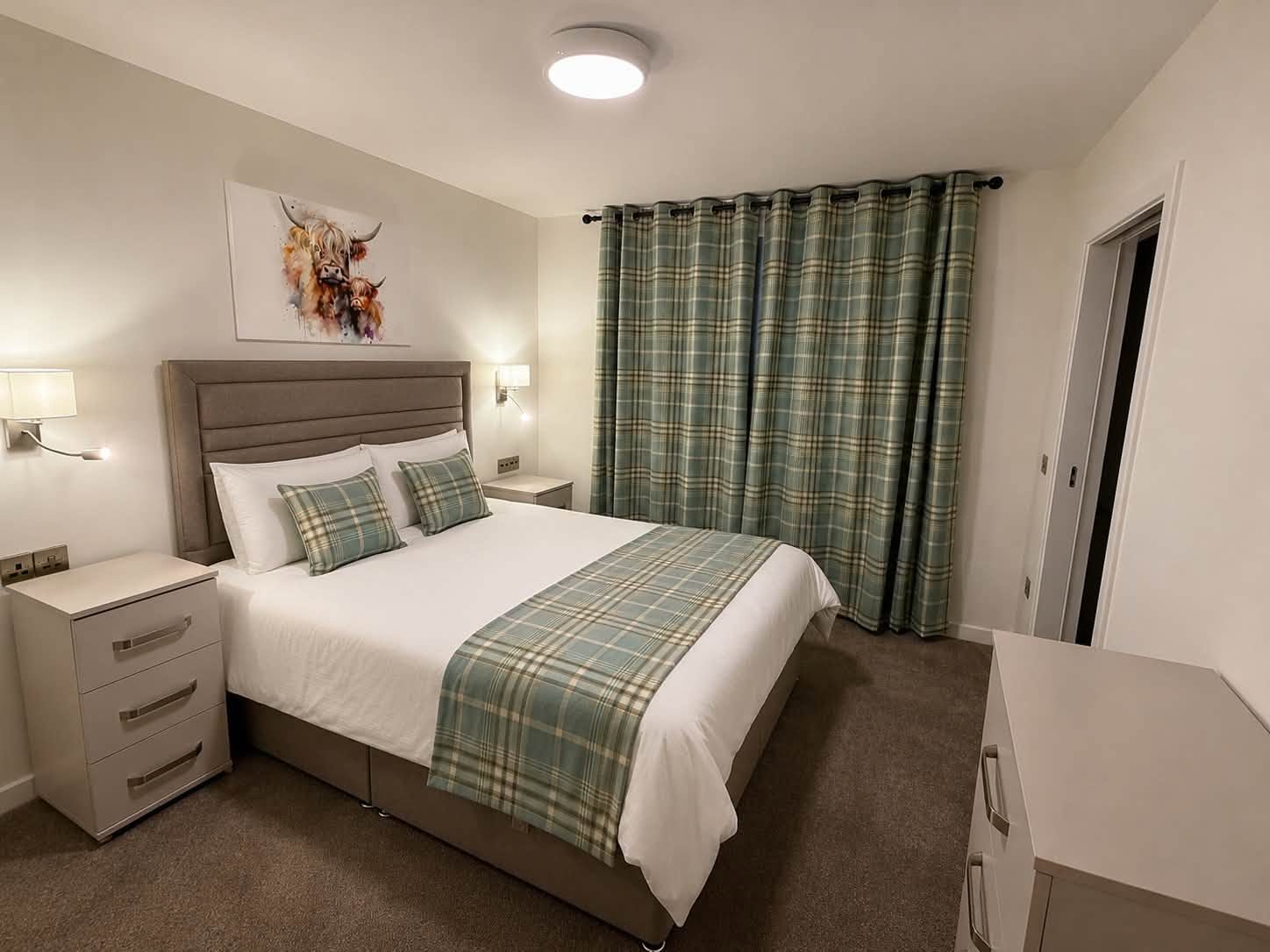 Bedroom furnished by Taylor's of Keith with teal tartan bedding and Highland cow artwork