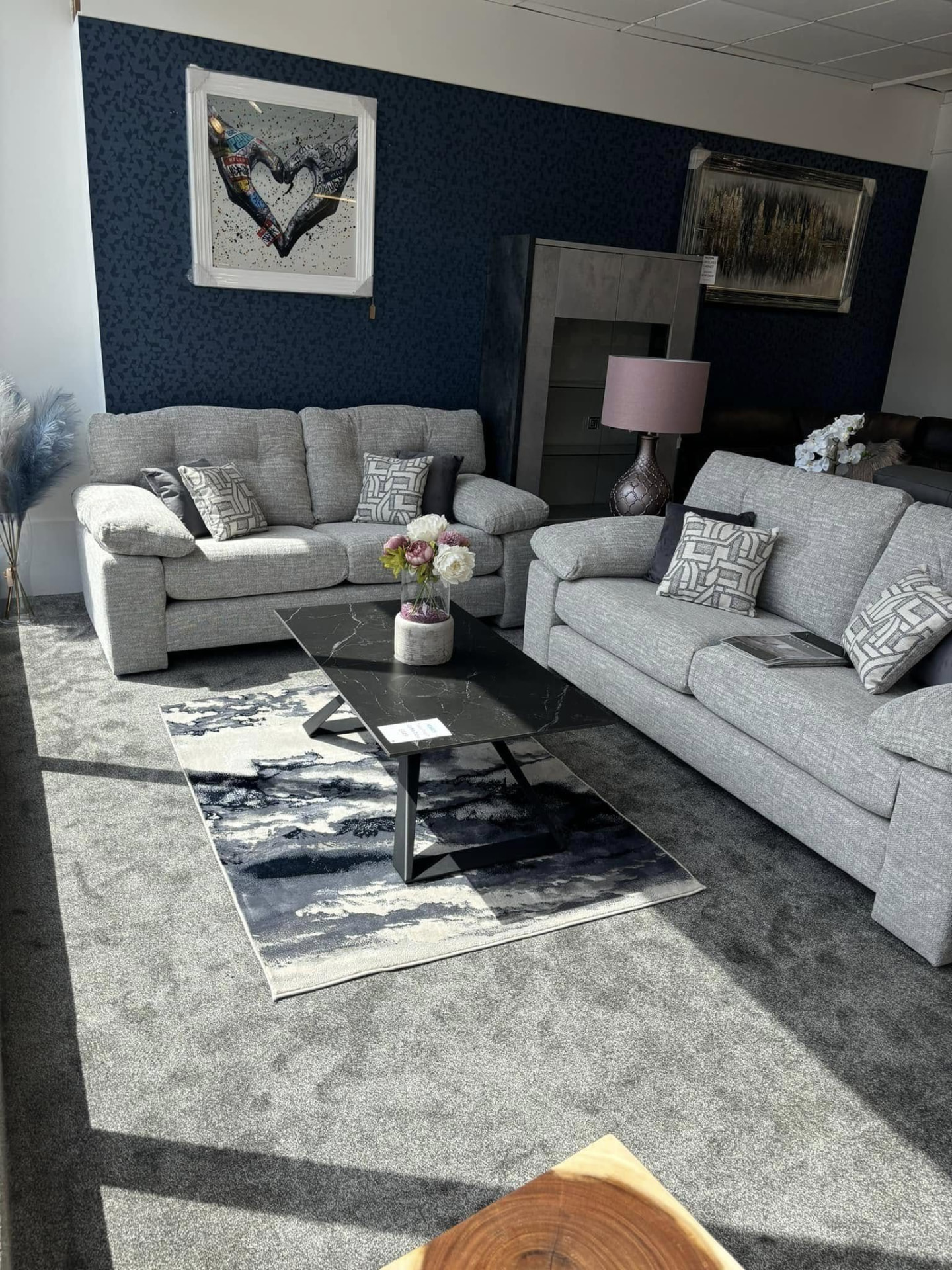 Grey fabric sofas displayed against a textured navy accent wall