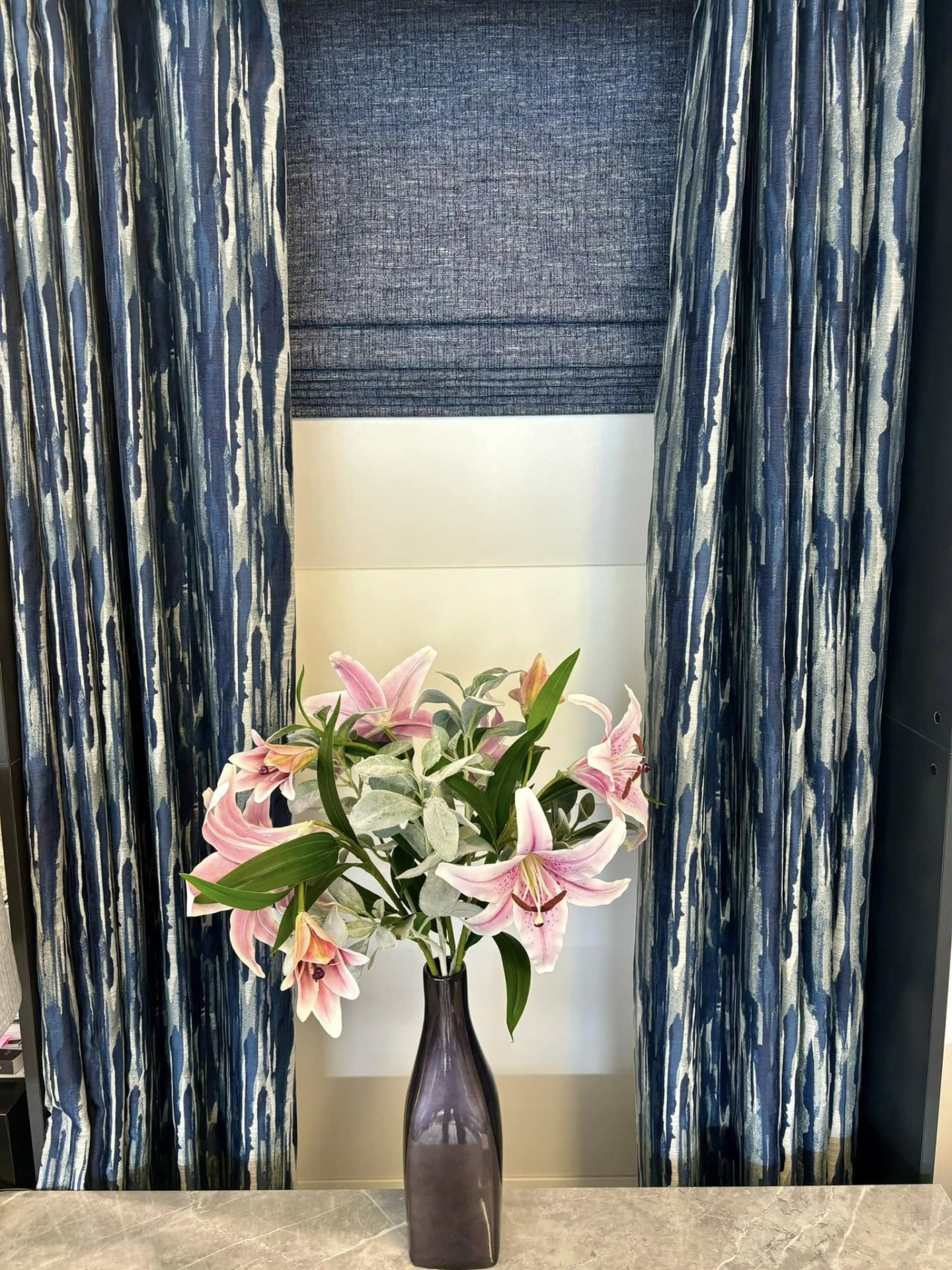 Blue patterned curtains and matching Roman blind fitted in a living room