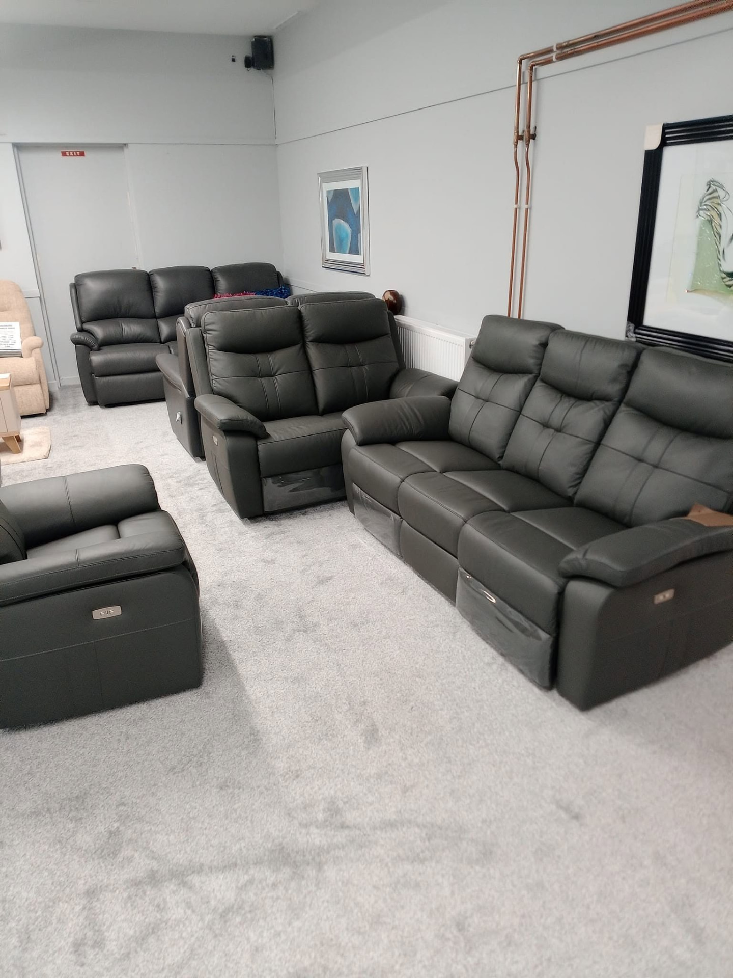 Black leather sofas and armchairs on the sofa showroom floor in Buckie