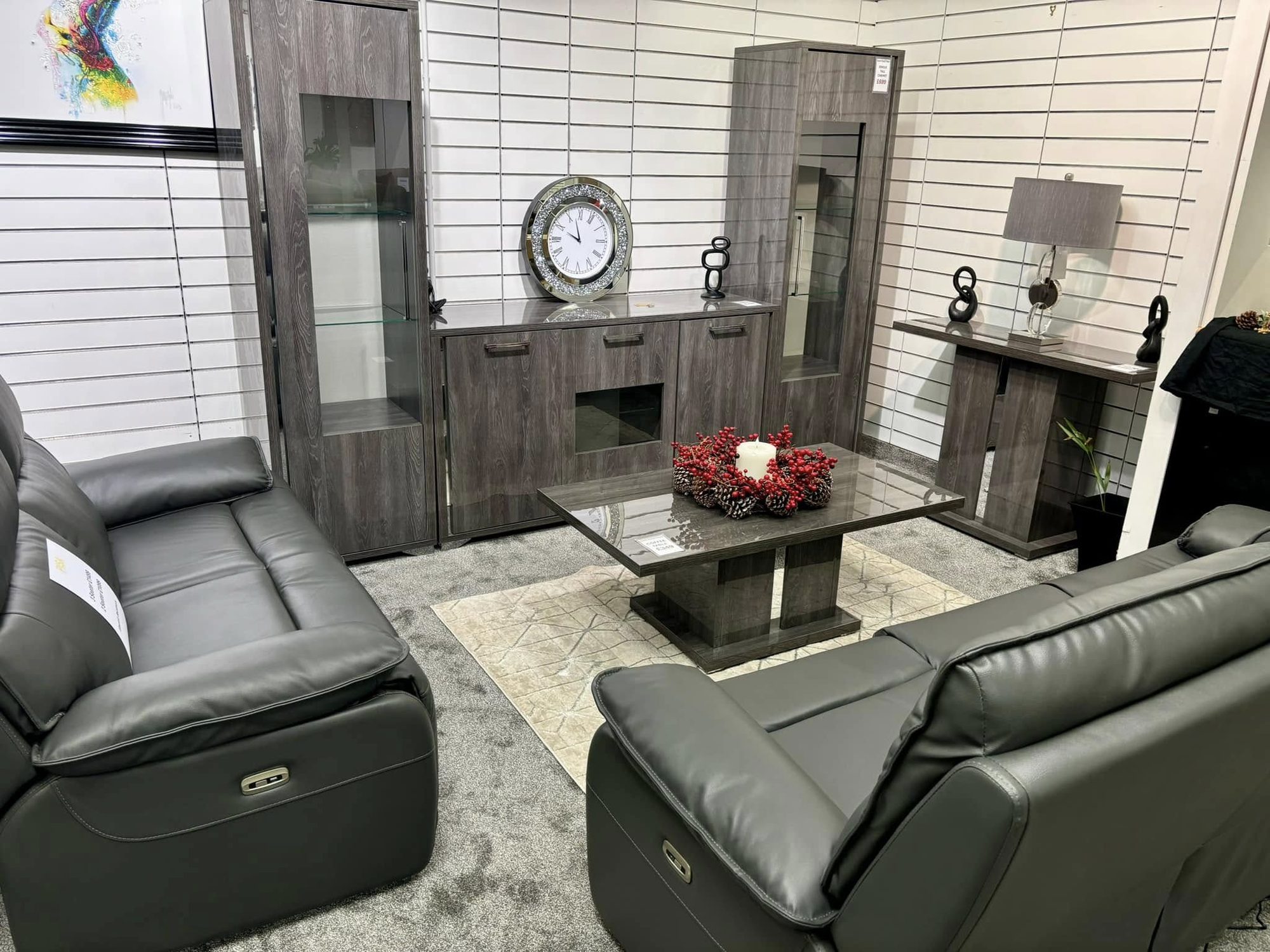 Grey leather recliner sofa set arranged in a furnished room setting