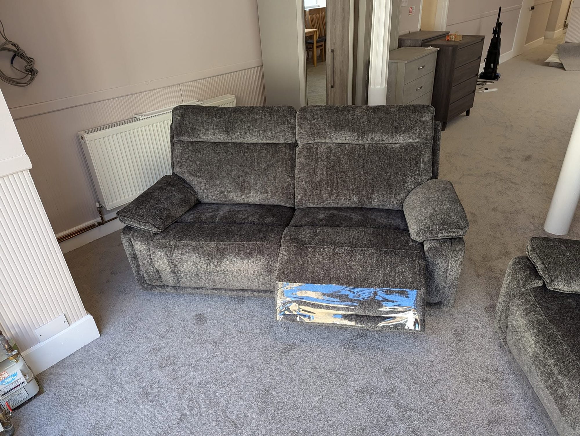 Grey chenille two-seater recliner sofa on display in the Taylor's sofa showroom