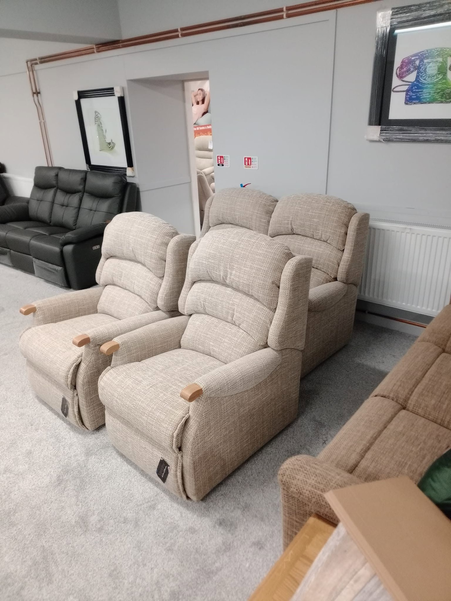 Pair of cream upholstered recliner armchairs in the Keith mobility seating showroom