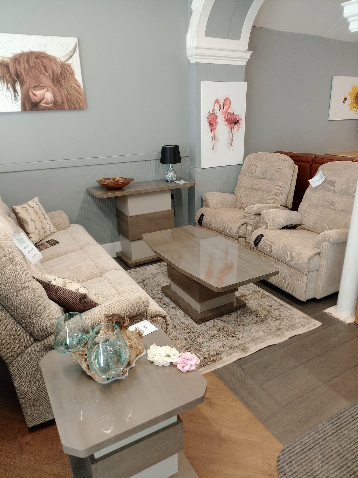 Living room set with cream recliner sofas and matching coffee tables on the showroom floor